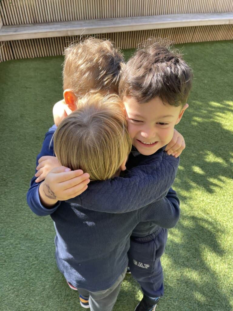 Boys outside smiling and hugging